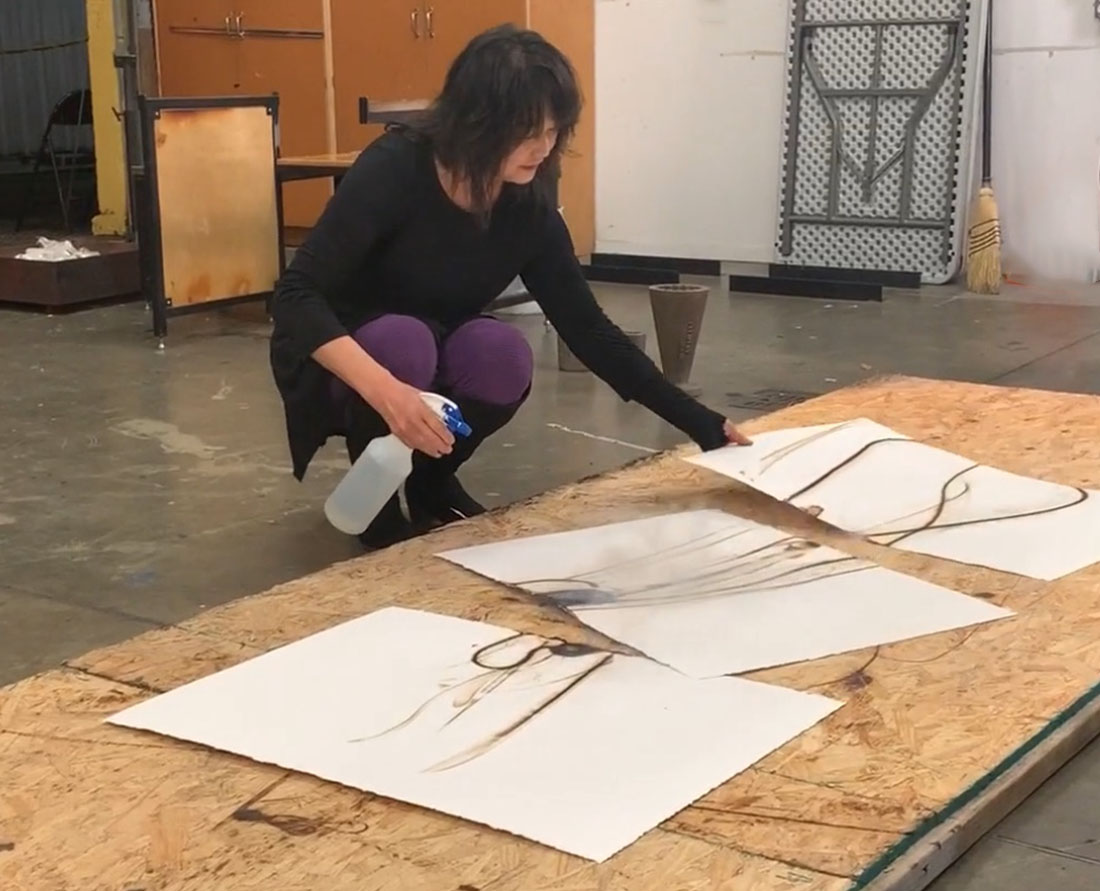 Seattle glass artist Etsuko Ichikawa creates her signature glass pyrograph drawing with molten glass demonstration Photo Wendy Nordvik-Carr